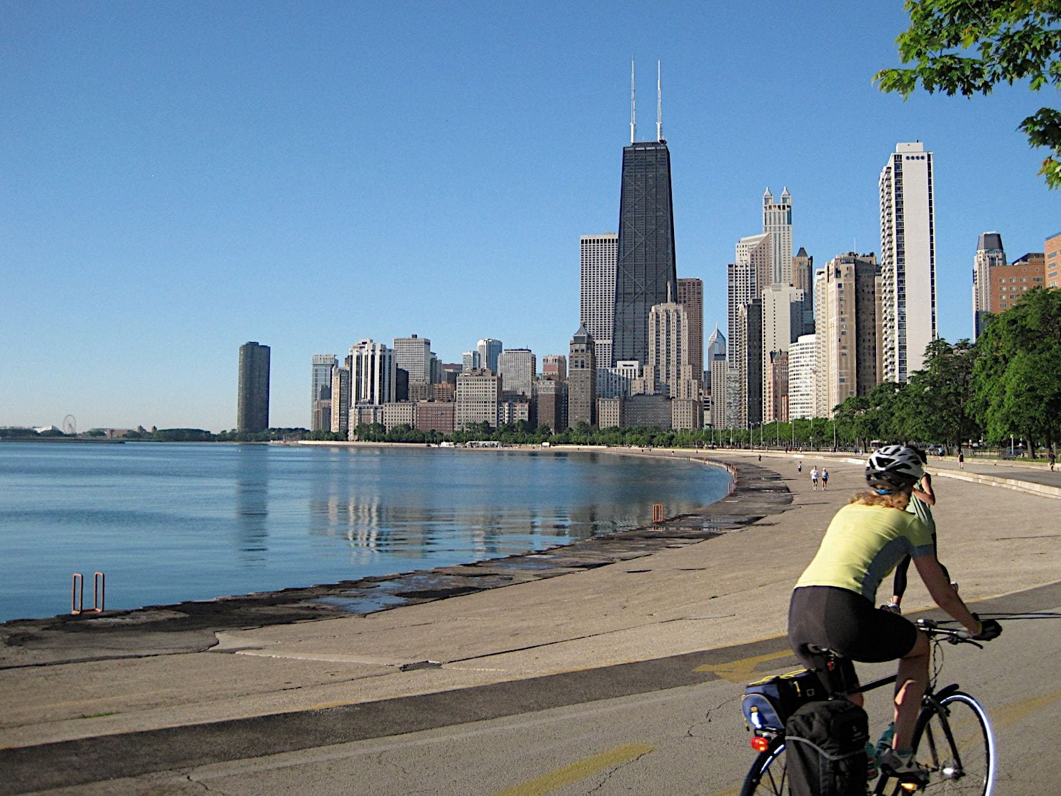 A person bikes Lake Shore Trail alongside skyscrapers in Chicago