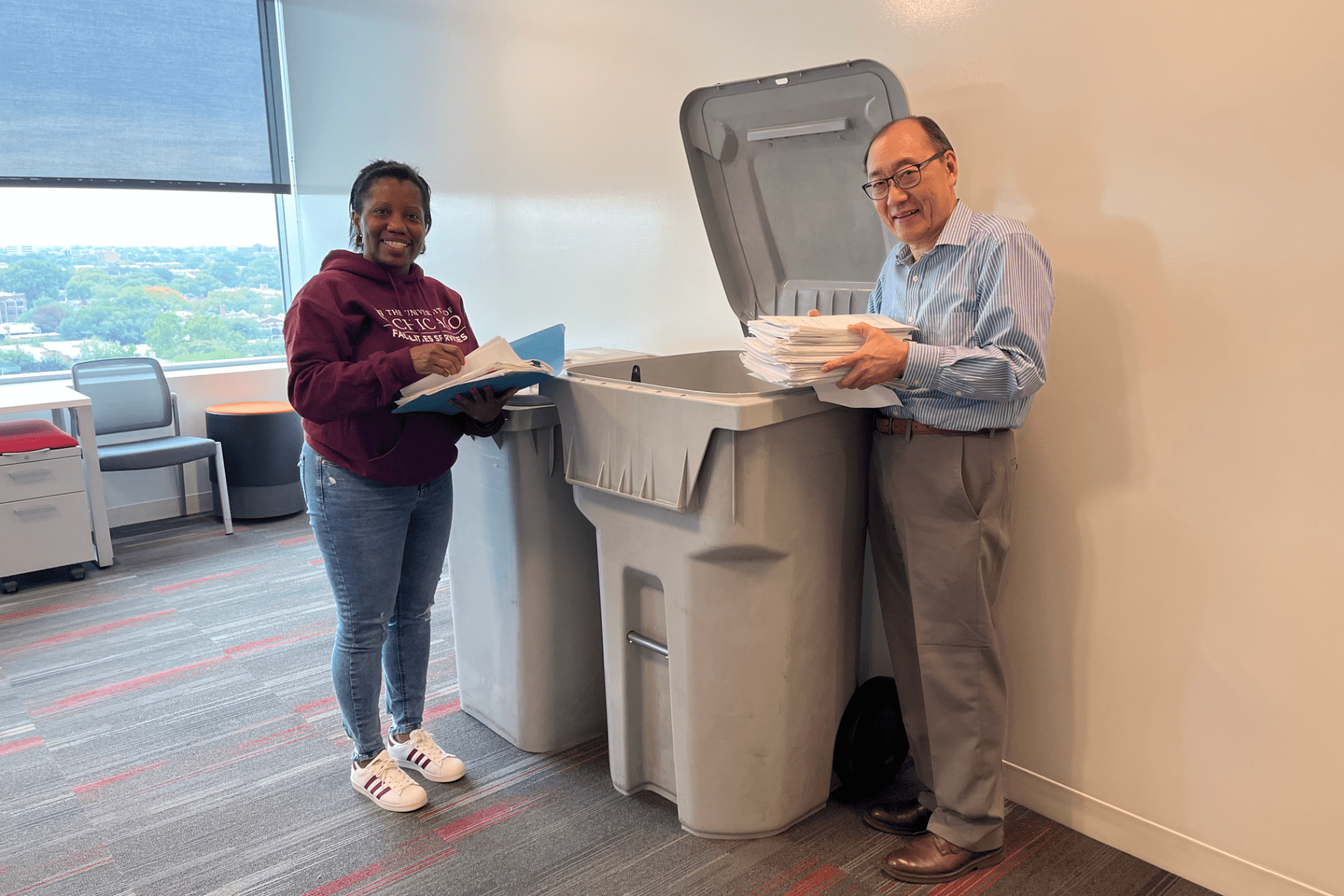 Tiffany Grant and Glenn Okazaki place papers for recycling in a bin